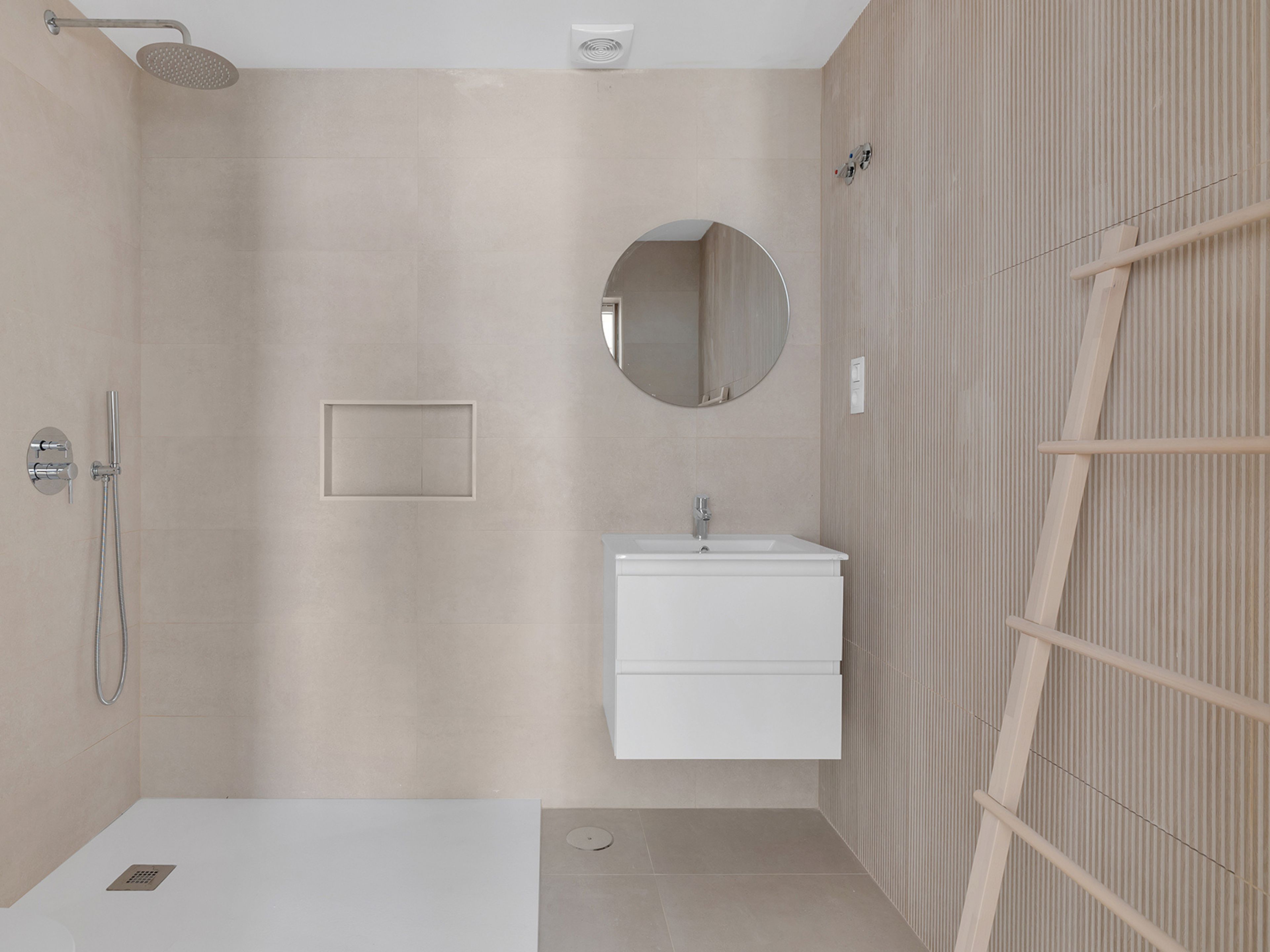 Ein modernes Badezimmer mit Dusche, Waschbecken und Spiegel.