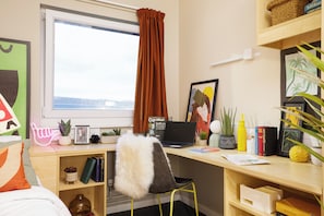 A well-organized workspace with a laptop, books, and decorative items. - Student Only William Murdoch (Birmingham)