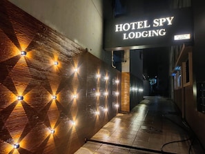 Un pasillo con un cartel de Hotel Spy Lodging, que presenta un diseño geométrico en la pared e iluminación.