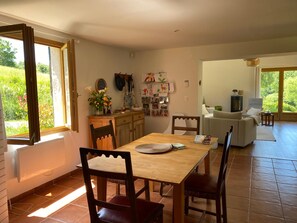 Un comedor con mesa y sillas de madera, una cocina con armarios y una encimera, y una sala de estar con sofá y chimenea.