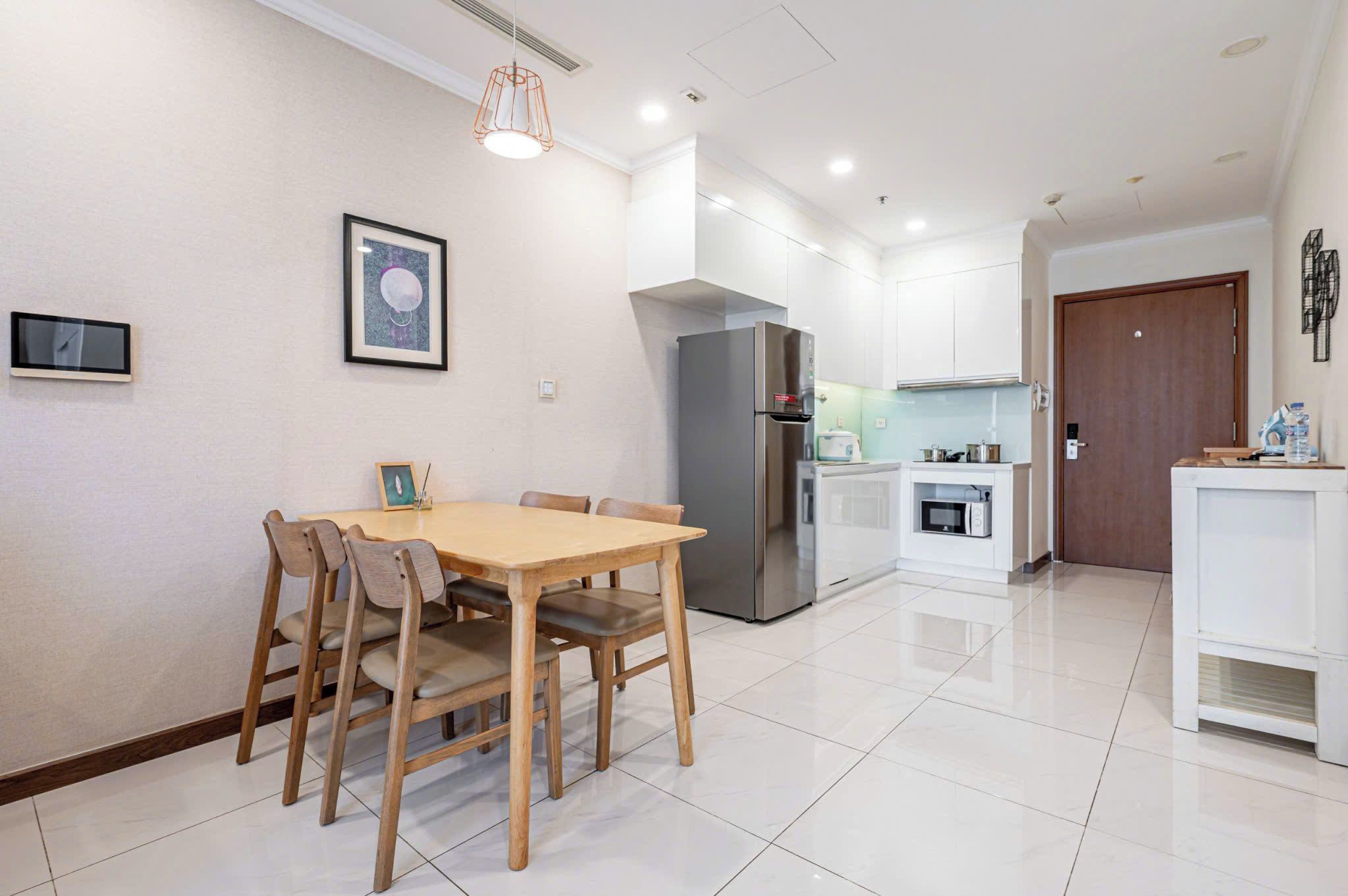 A modern kitchen with a stainless steel refrigerator, a microwave, and a small countertop area.