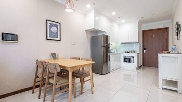 A modern kitchen with a stainless steel refrigerator, a microwave, and a small countertop area.
