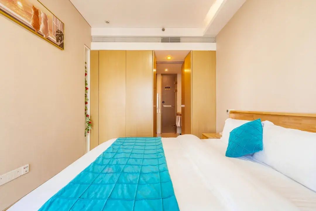 Ein Hotelzimmer mit einem Bett, einer Tür zu einem Badezimmer und einem an der Wand hängenden Bild.