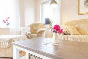 A living room with a wooden coffee table, a floor lamp, and a sofa with cushions. - Your spacious vacation home, Anita, in St. (Sankt Peter-Ording)