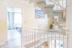 A modern interior with a staircase, a view of a bedroom, and a painting on the wall. - Your spacious vacation home, Anita, in St. (Sankt Peter-Ording)