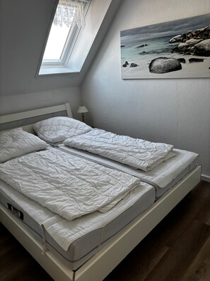 A bedroom with a bed, a window, and a painting on the wall. - Apartment 'Lina' with Wi-Fi (Grömitz)