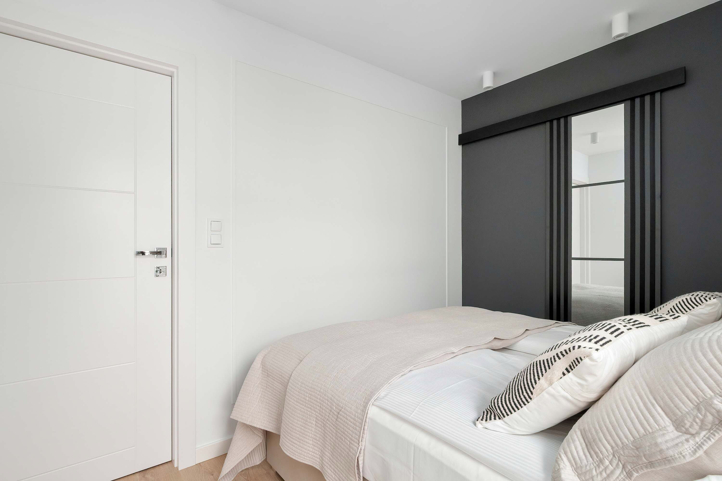 Ein Schlafzimmer mit einem Bett, einem Kleiderschrank und einem fenster mit Vorhängen.