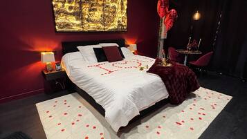A modern bedroom with a large bed, a red carpet, and a wall art piece.
