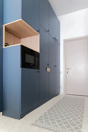 Une cuisine moderne dotée d’appareils électroménagers intégrés et d’une étagère en bois.