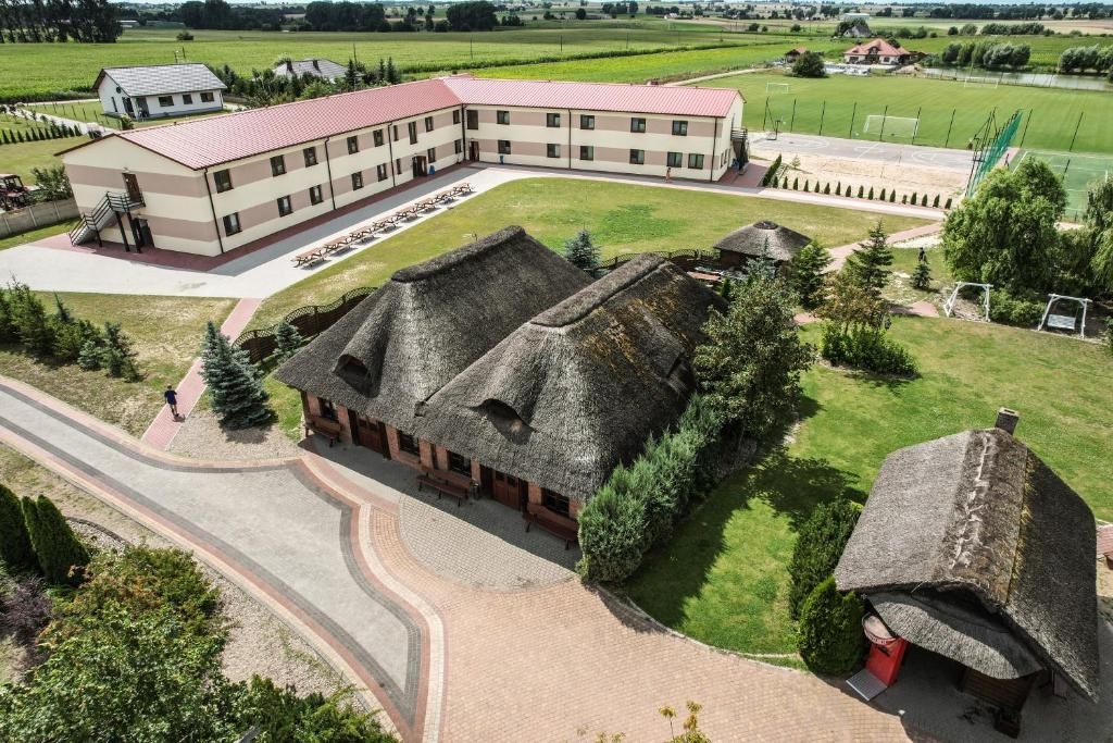 A building with a red roof and a thatched-roof structure.