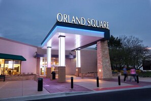 Une entrée d’immeuble avec une enseigne indiquant « ORLAND SQUARE » et une galerie couverte.