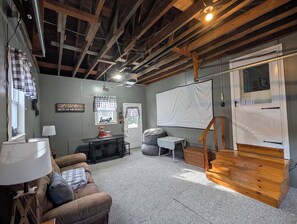 Una habitación acogedora con techo de madera, una pizarra, un sofá y una pequeña mesa con lámpara.
