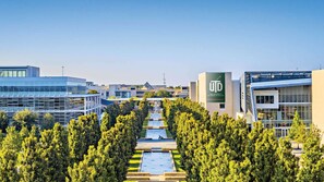 A university campus with modern buildings, a central pathway, and lush greenery. - Near Allen Premium Outlets + Onsite Dining & Pool (Allen)