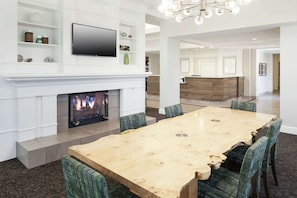A spacious living area with a fireplace, a large wooden dining table, and comfortable seating. - Close to Credit Union of Texas Event Center + Pool (Allen)