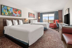 A hotel room with a large bed, two smaller beds, a desk, a chair, a TV, and artwork on the walls. - Close to Allen Premium Outlets + Onsite Dining (Allen)