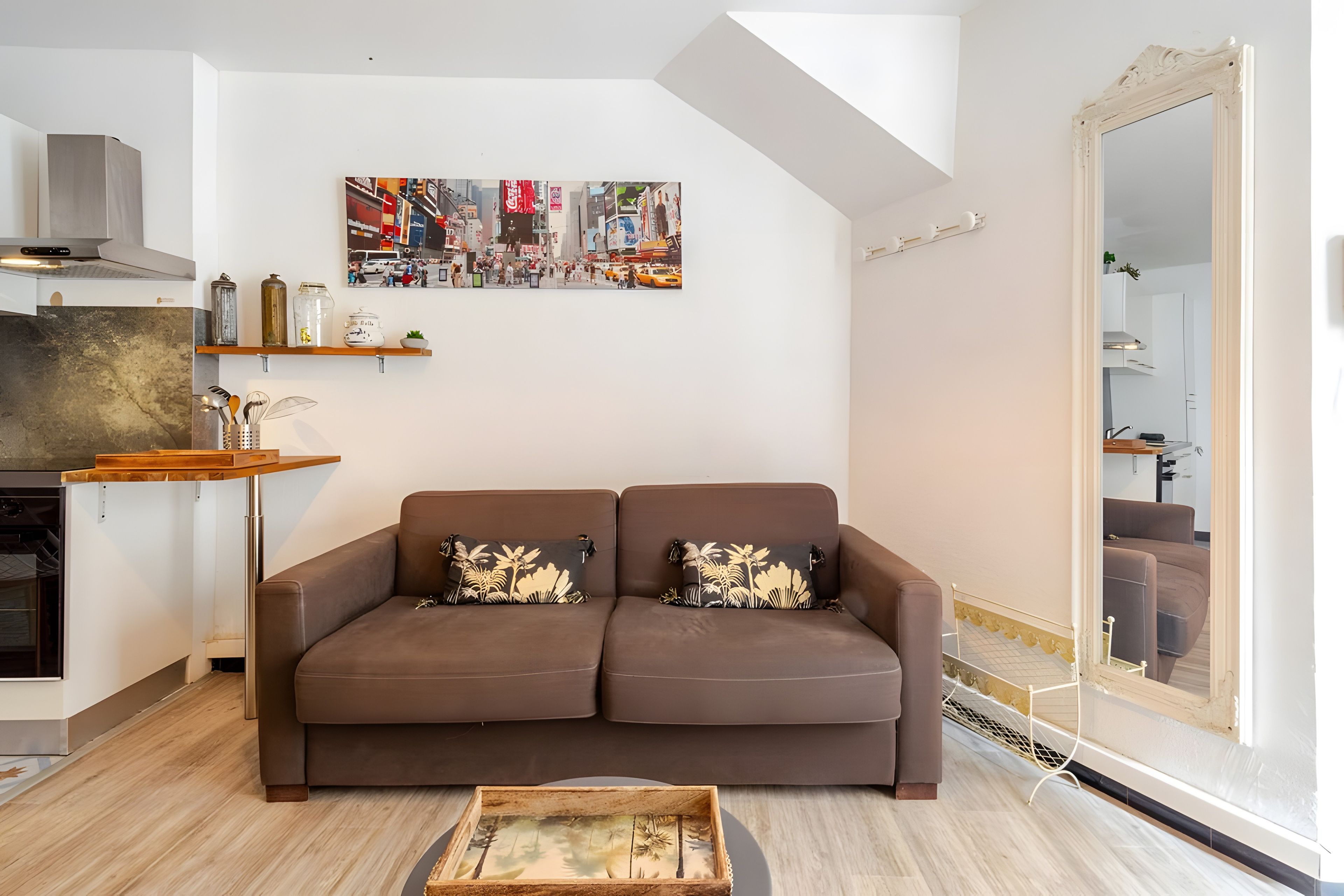 Una sala de estar moderna con un sofá marrón, una mesa de centro y una pintura de un paisaje urbano en la pared.