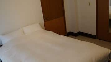 Un dormitorio con cama, armario de madera y una puerta.
