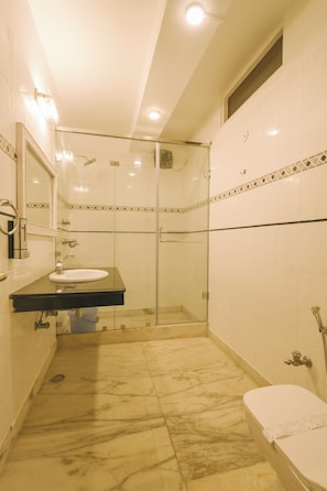 A bathroom with a glass shower enclosure, a sink, and a toilet. - The Willow Way (Nainital)