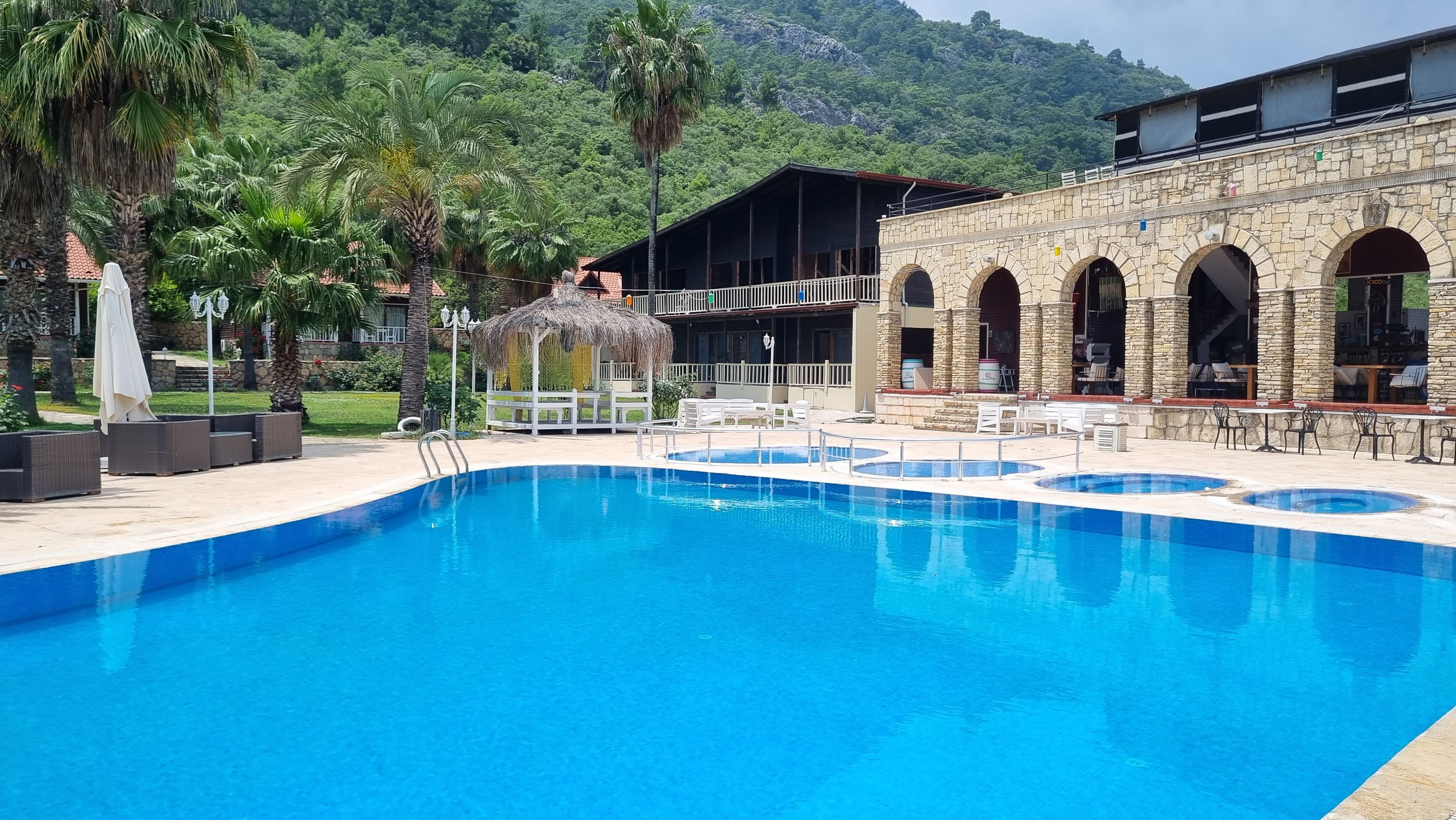 A swimming pool with a stone building in the background.