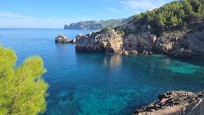 A coastal landscape with clear blue waters, rocky cliffs, and dense greenery. - New Listing (Deià)