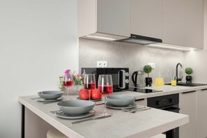 A modern kitchen with a central island, built-in appliances, and a minimalist design. - Łódź | Srebrzyńska 12 | Modern Apartment | Air conditioning | Parking (Łódź)