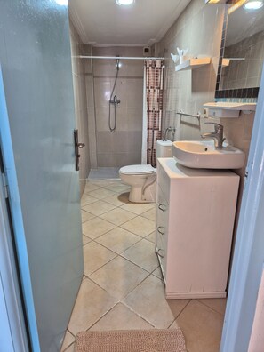 Ein Badezimmer mit Toilette, Dusche und Waschbecken.