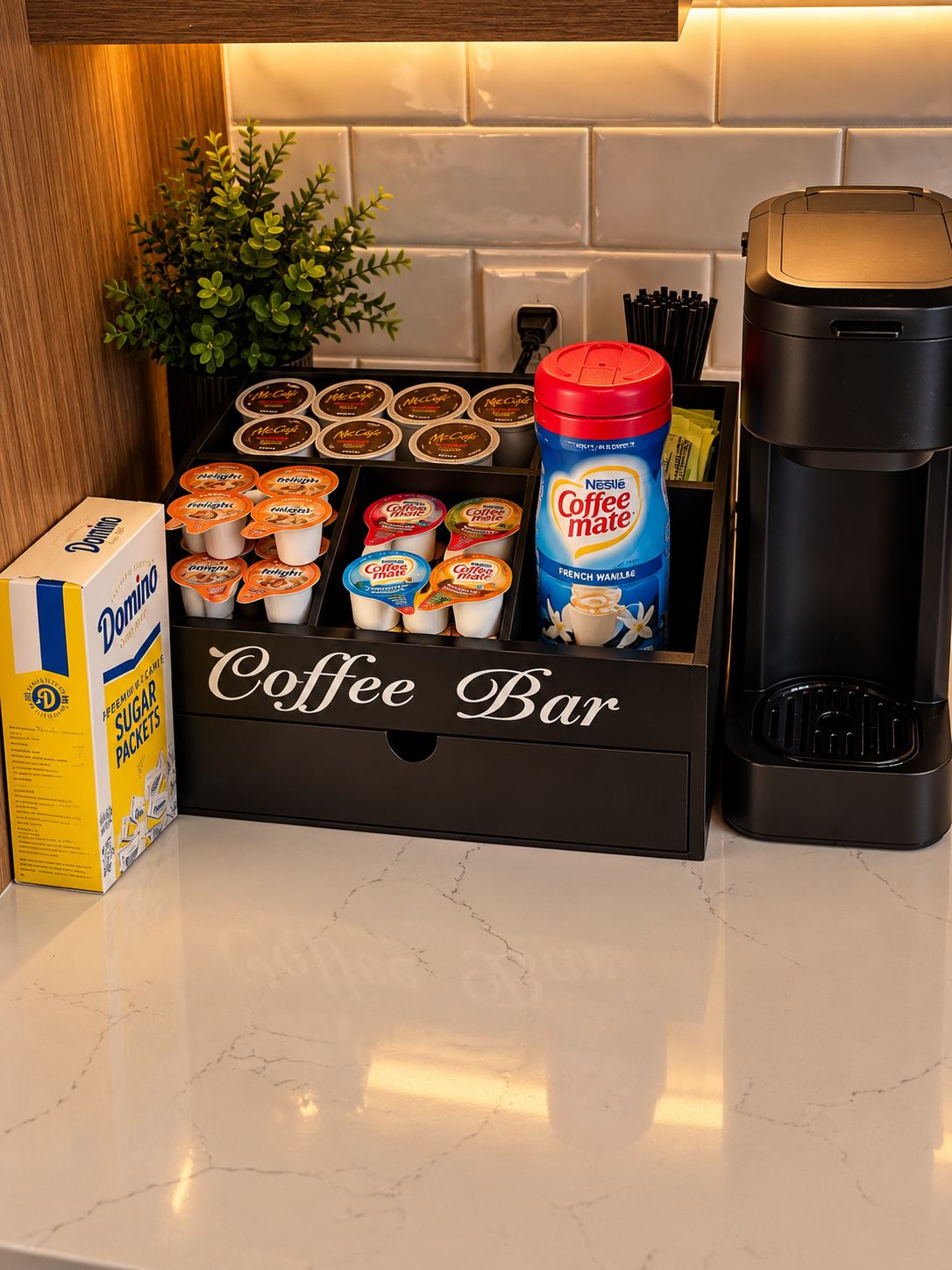 A coffee bar with various coffee products, a coffee maker, and a box of Domino sugar packets.