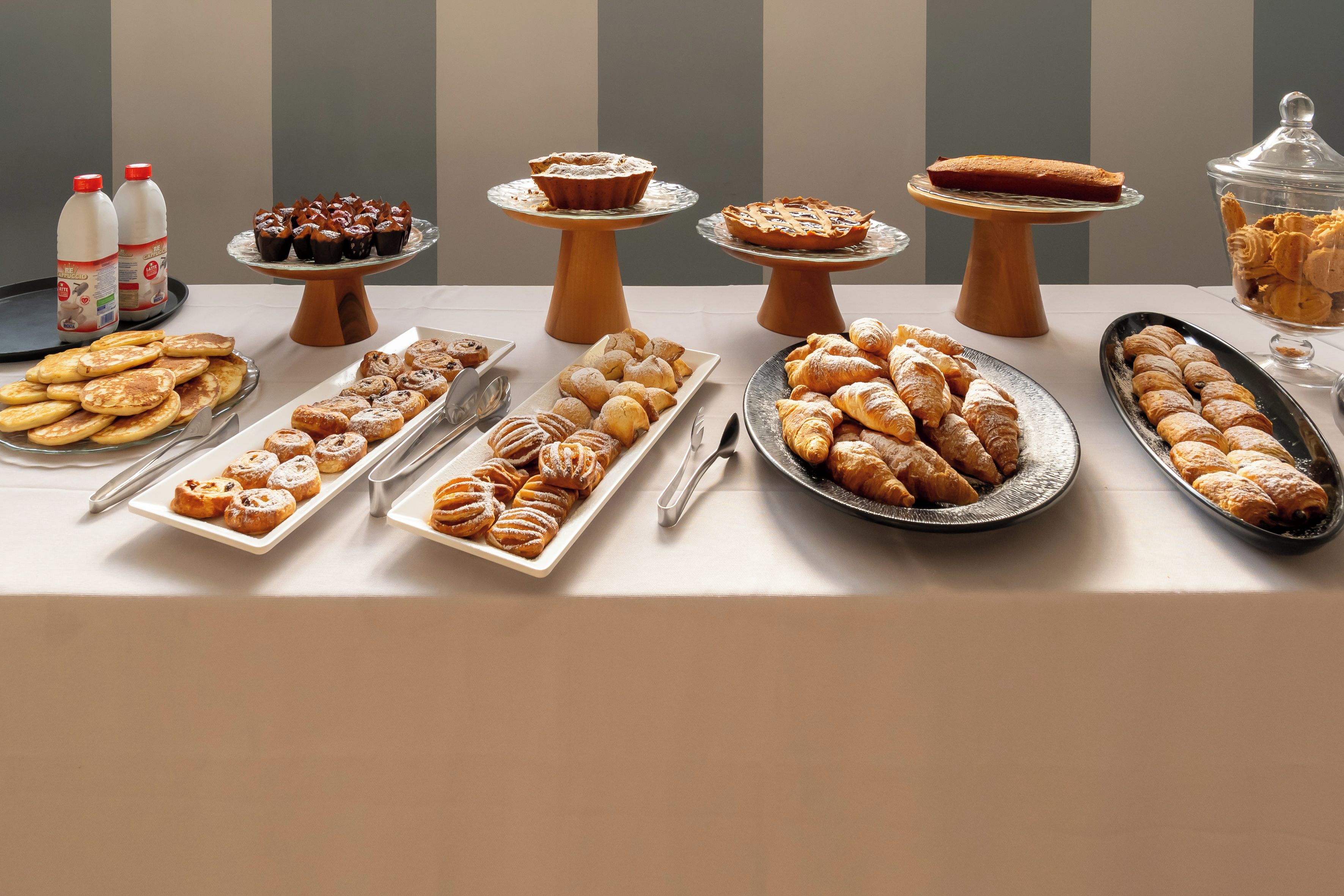 Una mesa de buffet con diversos pasteles y postres.