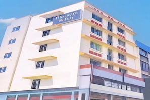 Un edificio de hotel de varios pisos con un letrero que dice 'Blossom Inn'.