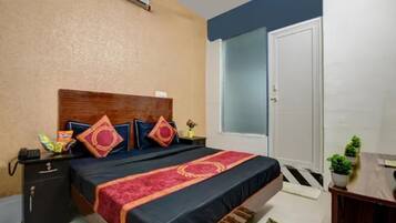 Une chambre à coucher avec un lit, des tables de chevet, une commode, une fenêtre et une porte.