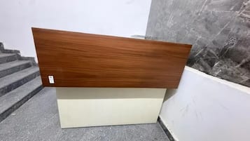 Un panneau en bois avec une étiquette, un socle blanc et un mur en marbre.