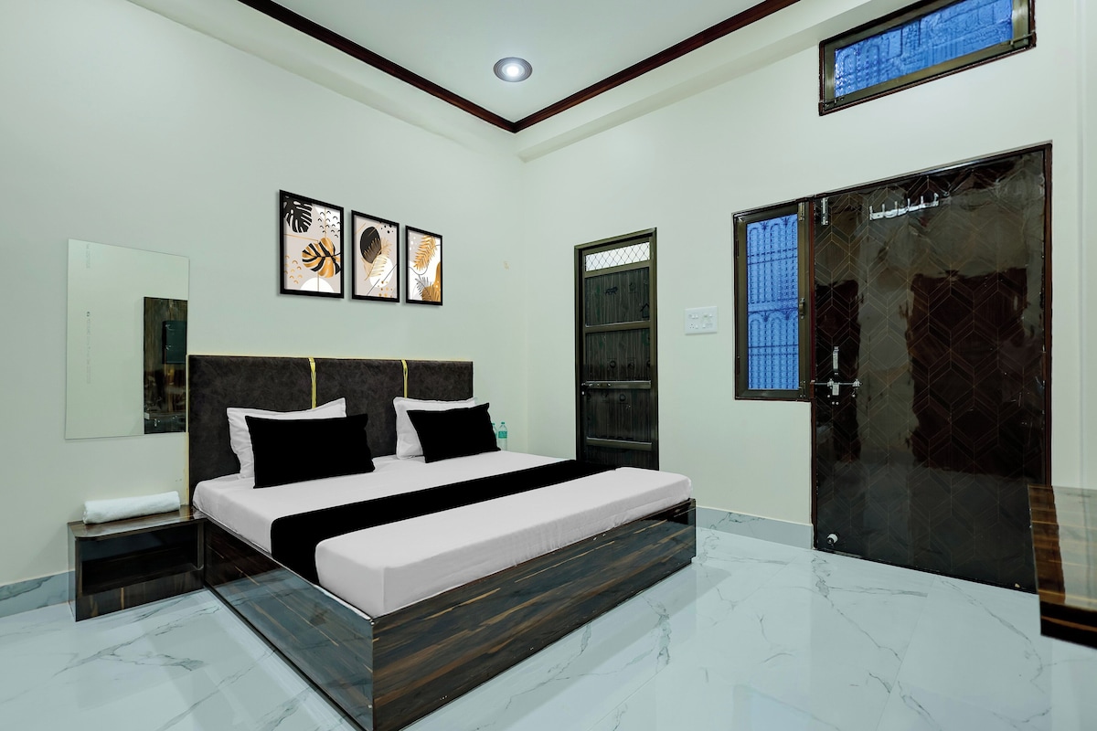 Une chambre moderne avec un grand lit, une table de chevet, un miroir et une porte avec une fenêtre.