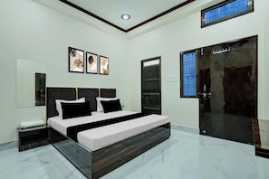 Une chambre moderne avec un grand lit, une table de chevet, un miroir et une porte avec une fenêtre.
