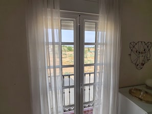 Una habitación con puerta corrediza de vidrio que da a un espacio exterior.