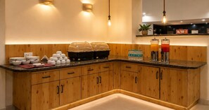 Una cocina moderna con armarios de madera, encimera de granito y una estación de café integrada.