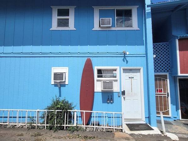 A blue building with a surfboard, a door labeled 'Office,' and a 'No Vacancy' sign. - AC, Dining Area, Prime Location! Maui Studio For 2 (Wailuku)