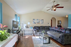 A living room with a sofa, coffee table, and a ceiling fan.