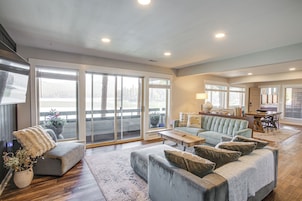 A spacious living room with a large sofa, a coffee table, and a dining area with a table and chairs.