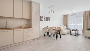 Eine moderne Küche mit Essbereich, einer Couch und einem großen Fenster.
