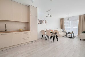 Eine moderne Küche mit Essbereich, einer Couch und einem großen Fenster.