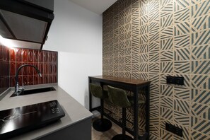 A modern kitchen with a built-in oven, a sink, and a countertop with a coffee machine. - A33 Signature Residences - Sol von Monaro * * * * * (Madrid)