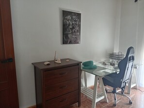 Une pièce comprenant un bureau, une chaise et un tableau accroché au mur.