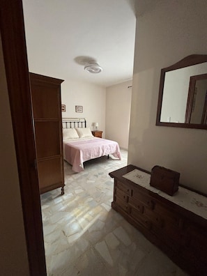 Un dormitorio con cama, cómoda y espejo.