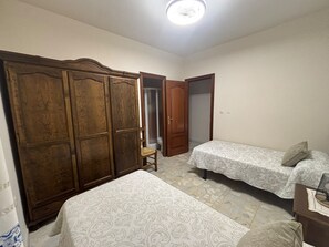 Un dormitorio con armario, cama y silla.