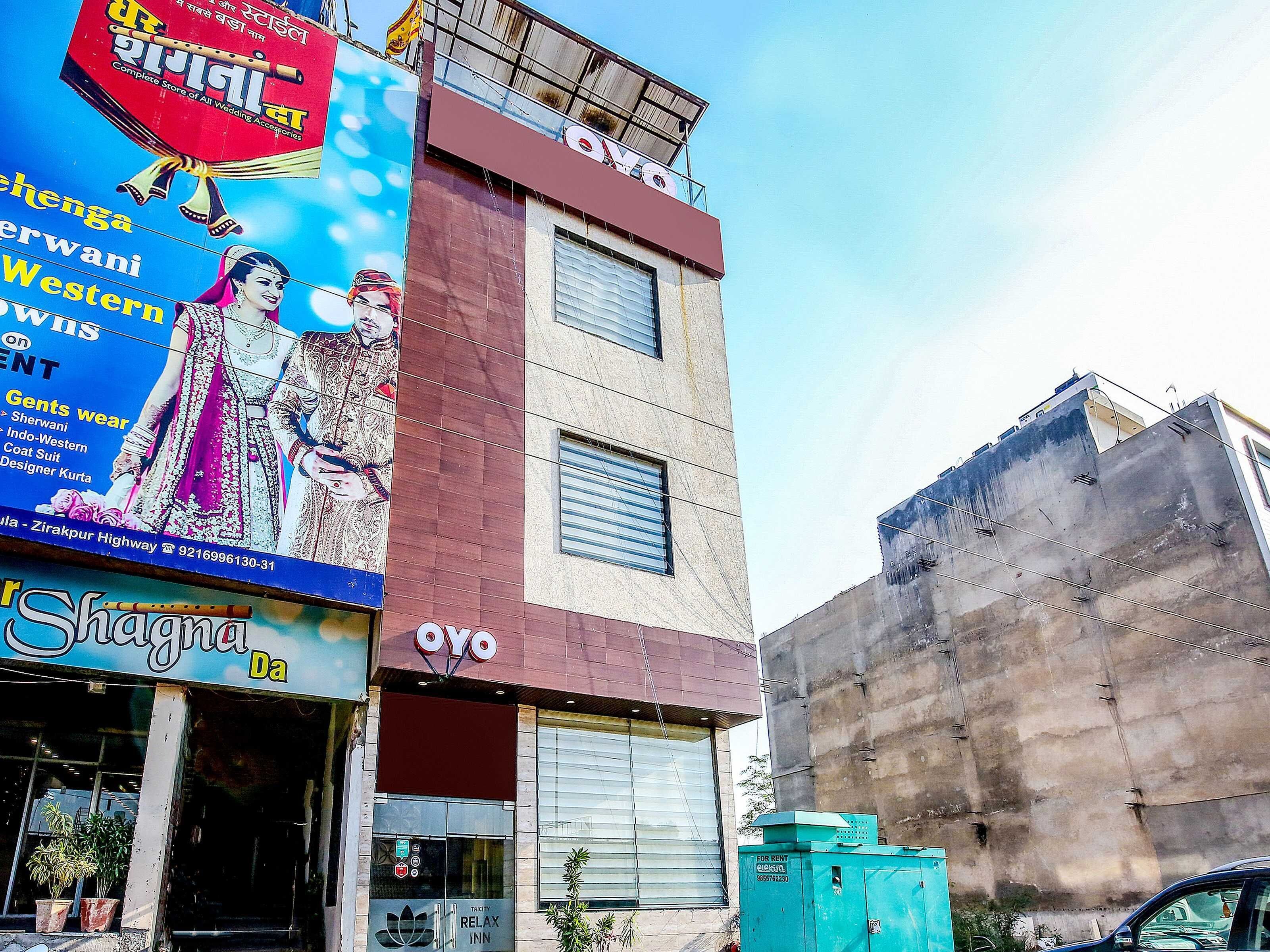 A building with a sign for 'Shagna Da' and 'OYO' hotel, featuring a large advertisement for wedding accessories.