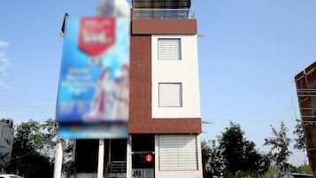 A two-story building with a flat roof and a large billboard on the side.