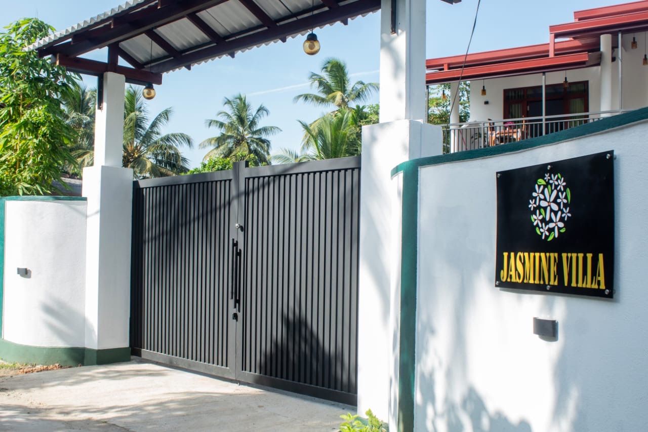 Une entrée fermée par un portail, sur laquelle on peut lire l’inscription « Villa Jasmine ».