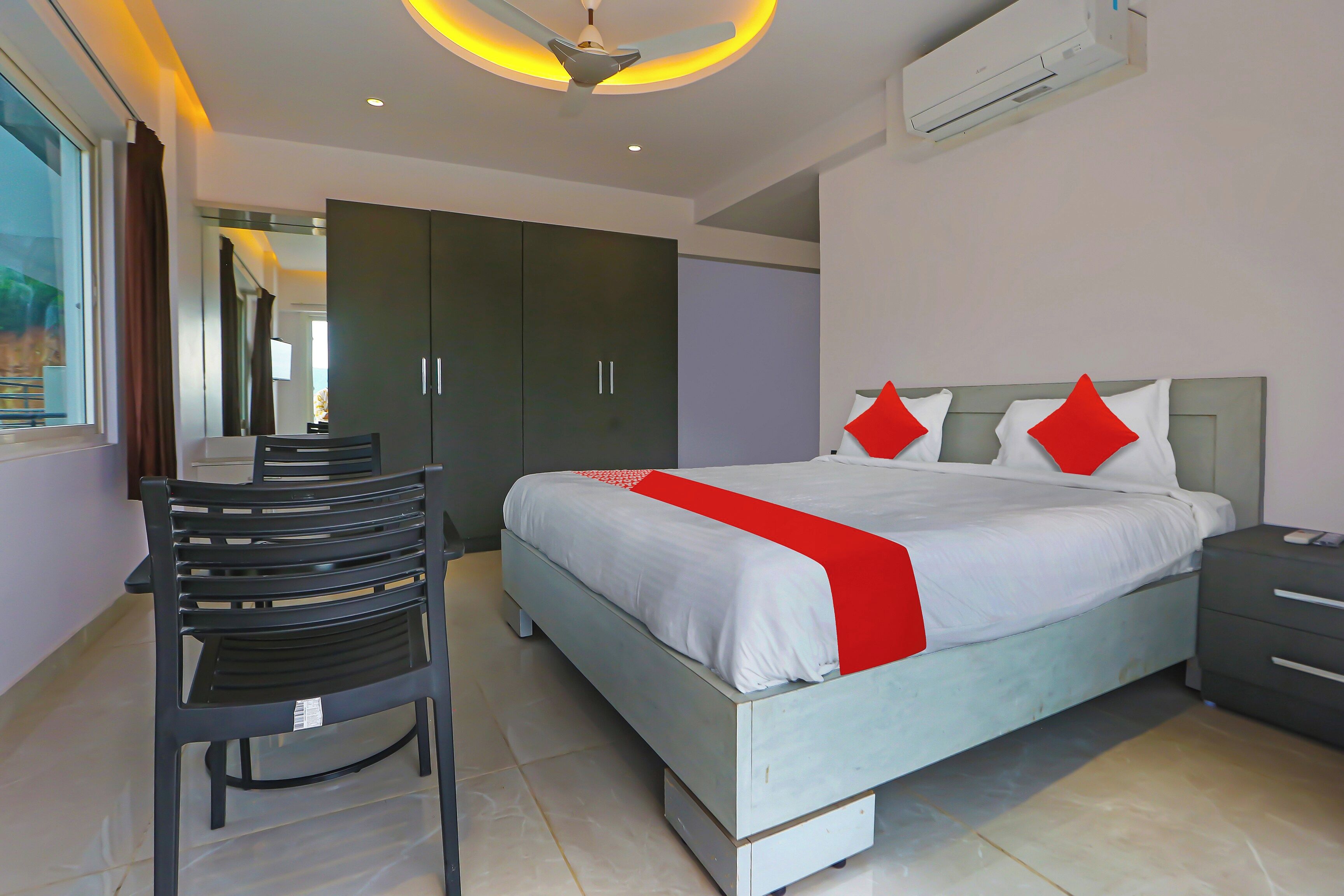 A modern bedroom with a bed, bedside table, and a desk with a chair.