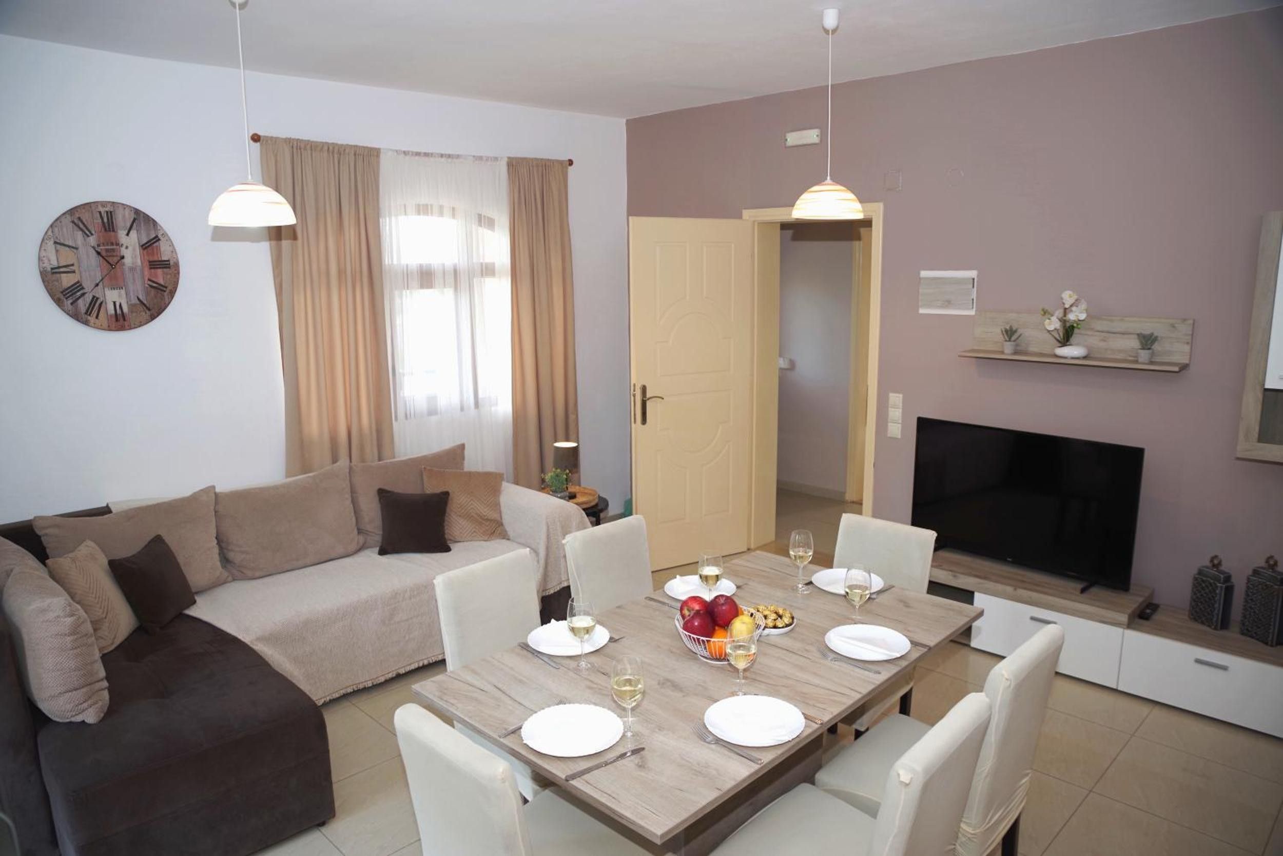 A modern living room with a sofa, dining table, and TV.