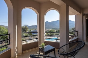 A balcony with a pool, a chair, and a table. - Villa 'Leondis' with Mountain View, Wi-Fi and Air Conditioning (Μελιδόνι)